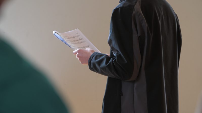 Person holding a sheet of music